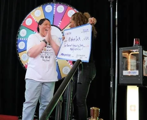 woman being presented large check