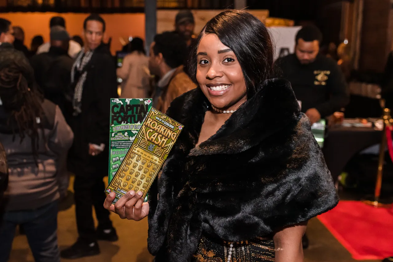 woman posing for a photo holding the Roaring Cash scratcher