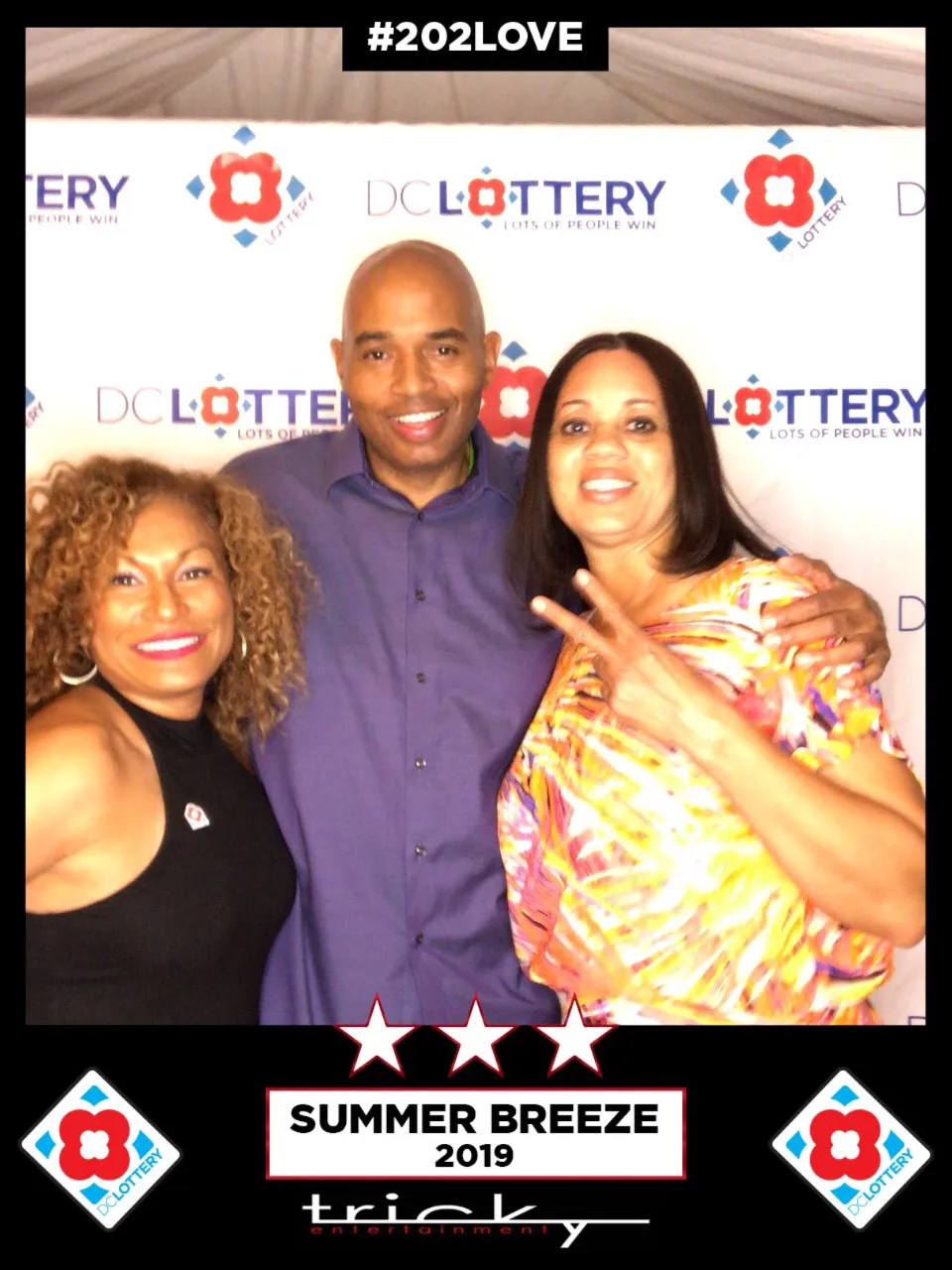 Three people posing for a photo in the DC Lottery photo booth