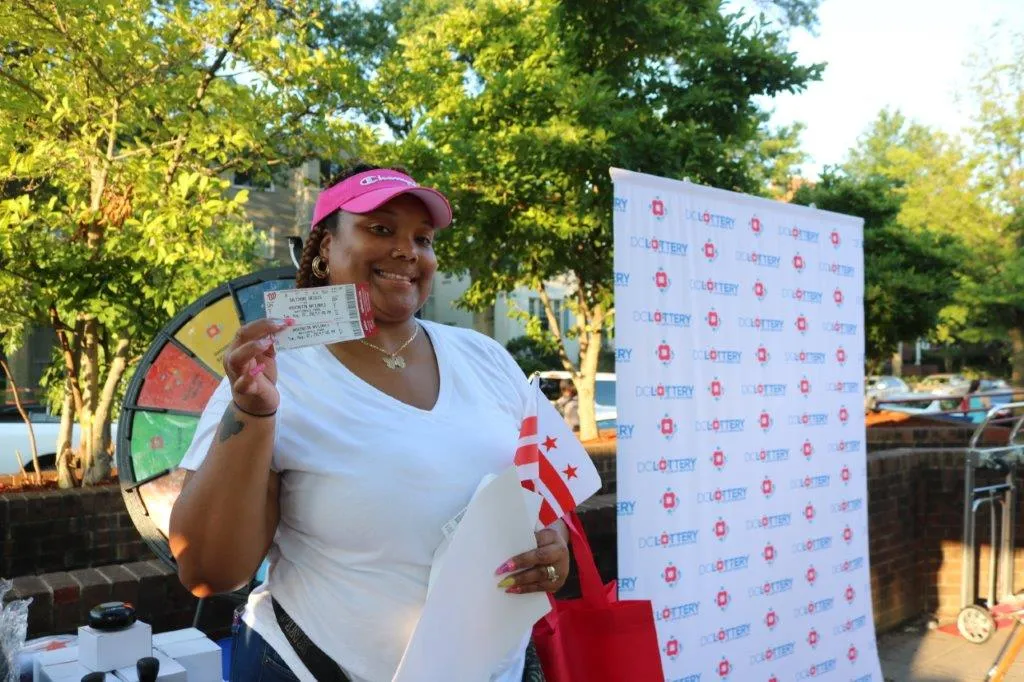 Player posing for a photo at the DC Lottery Prize Wheel